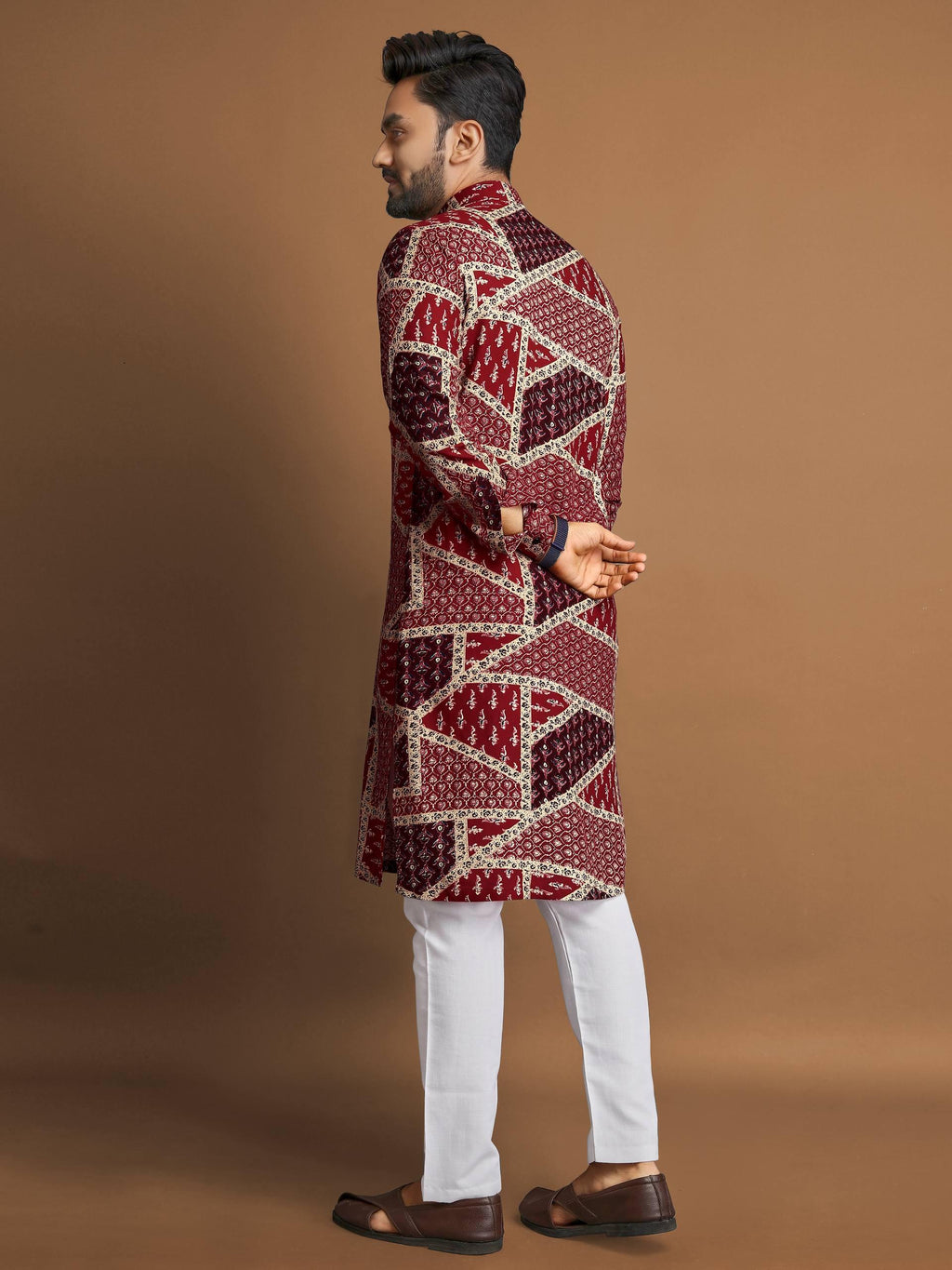 Side view of man wearing men's cotton foil print kurta with geometric patterns paired with white pants and brown shoes