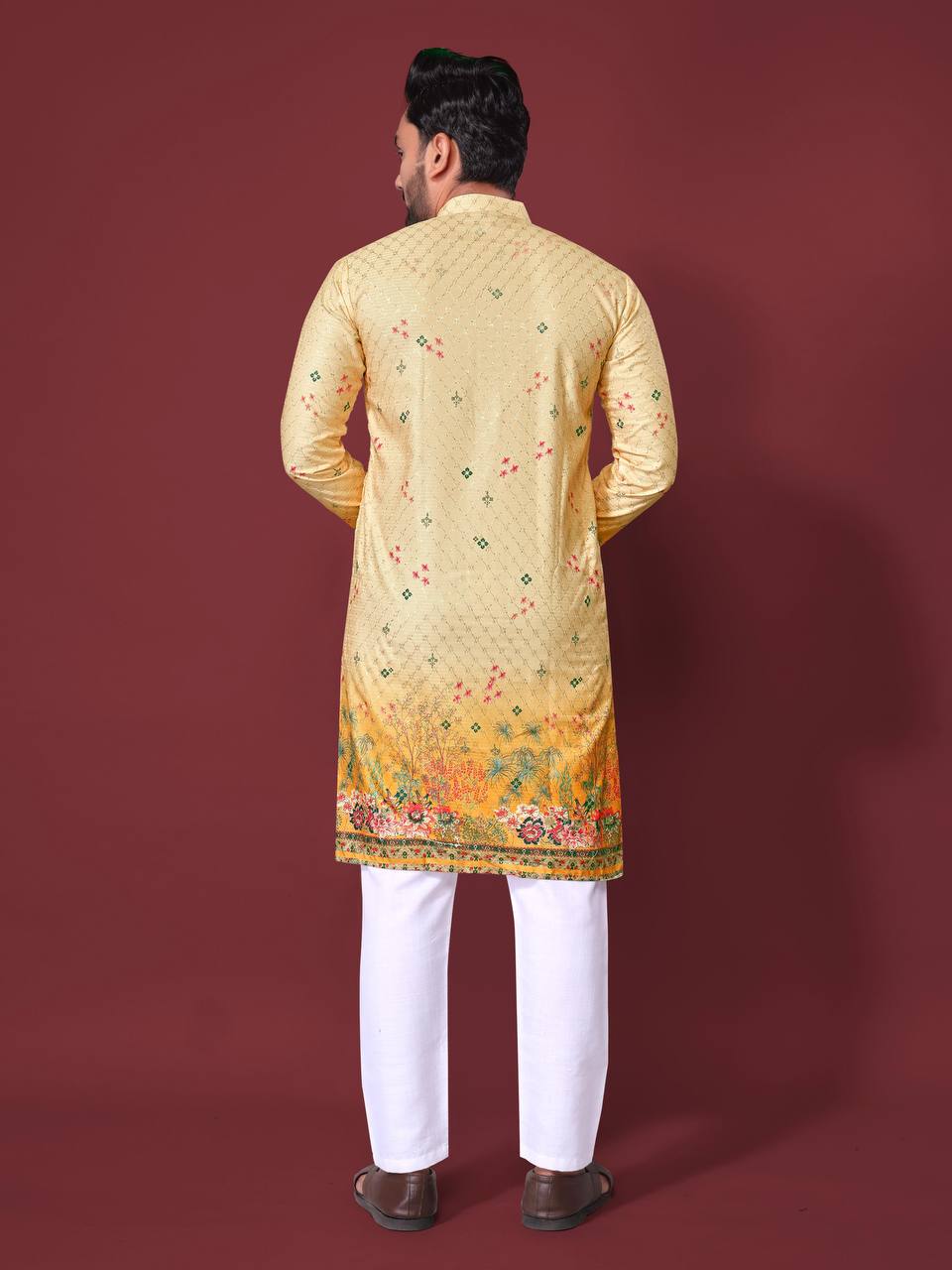 Back view of a man wearing a yellow embroidered kurta with floral details by Pehrang paired with white pants